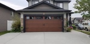 black roof house, brown wood garage, and paved driveway in red deer
